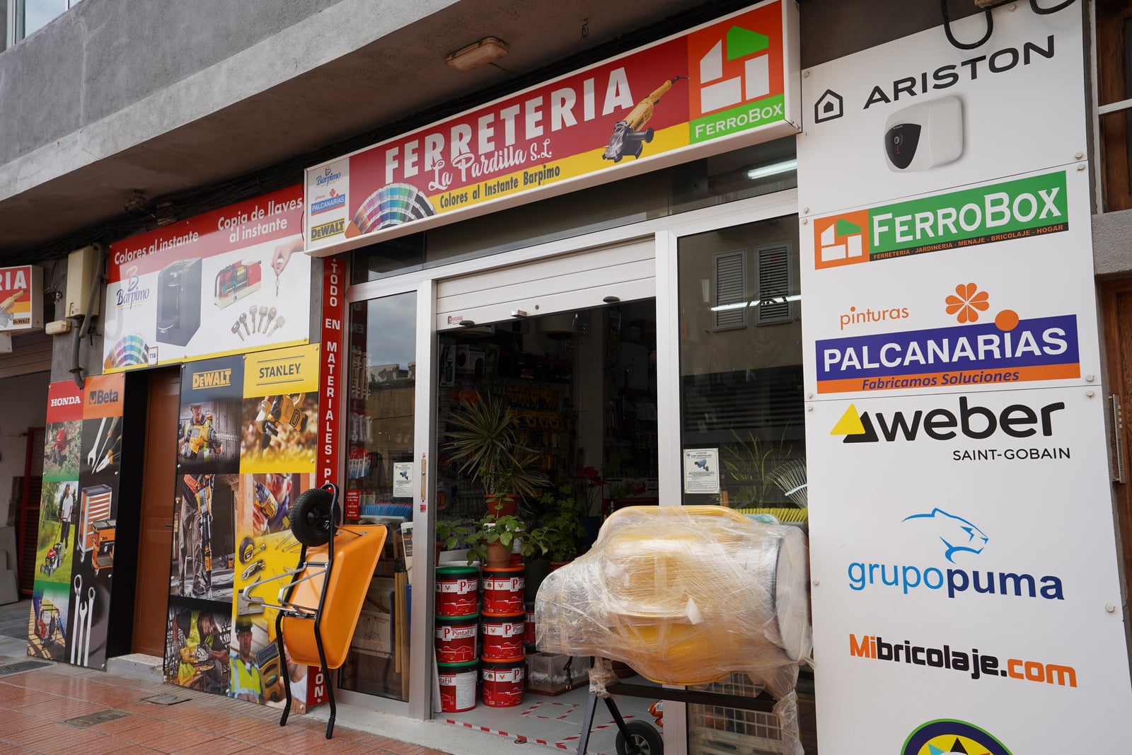 Fachada de Ferretería La Pardilla con el cartel del negocio y marcas colaboradoras
